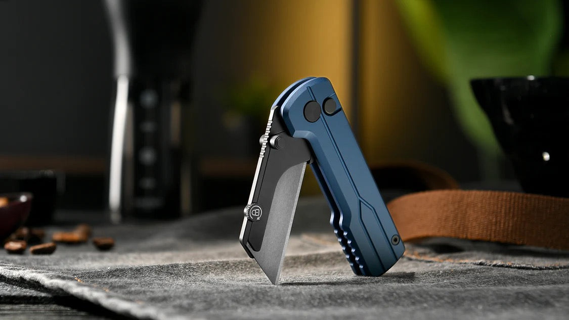 Folded OKnife U1 Ultra Navy Blue utility knife on a textured surface