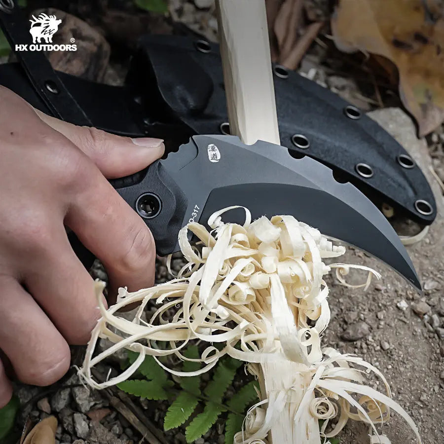 HX Outdoors Shadowfang Claw D-317 in use – carving wood with the curved karambit blade