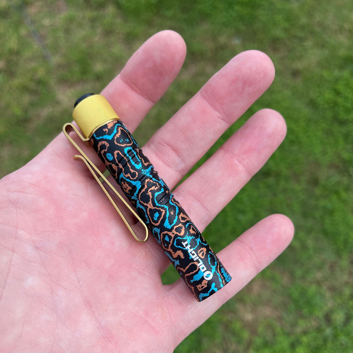 Olight I3T 2 EOS CamoCarbon Shipwreck in hand size comparison