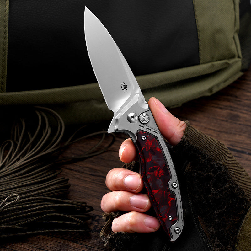 Klaken B05 Hermod J214-RedCarbonTi red marbled carbon fiber and titanium handle held in hand