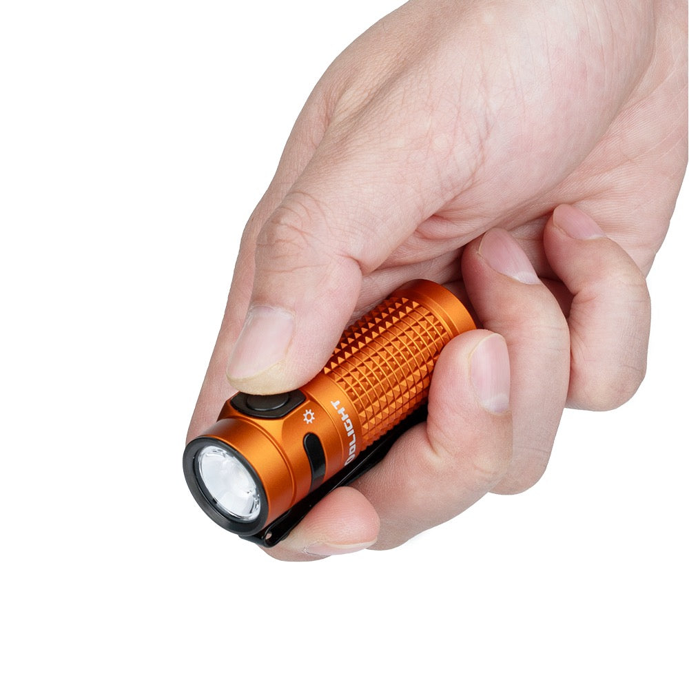 Olight Baton 4 Orange held in hand showing compact EDC pocket size