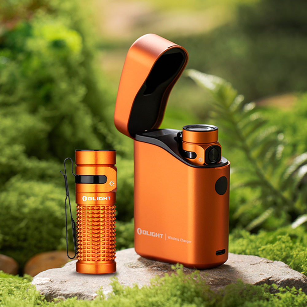 Olight Baton 4 Premium Orange flashlight and open wireless charging case outdoors on rock