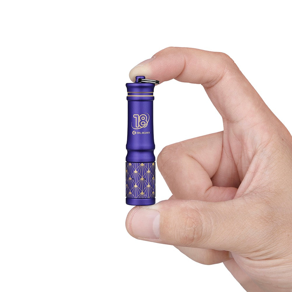 Olight i3E EOS 18th Anniversary Edition held in hand showing its keychain size