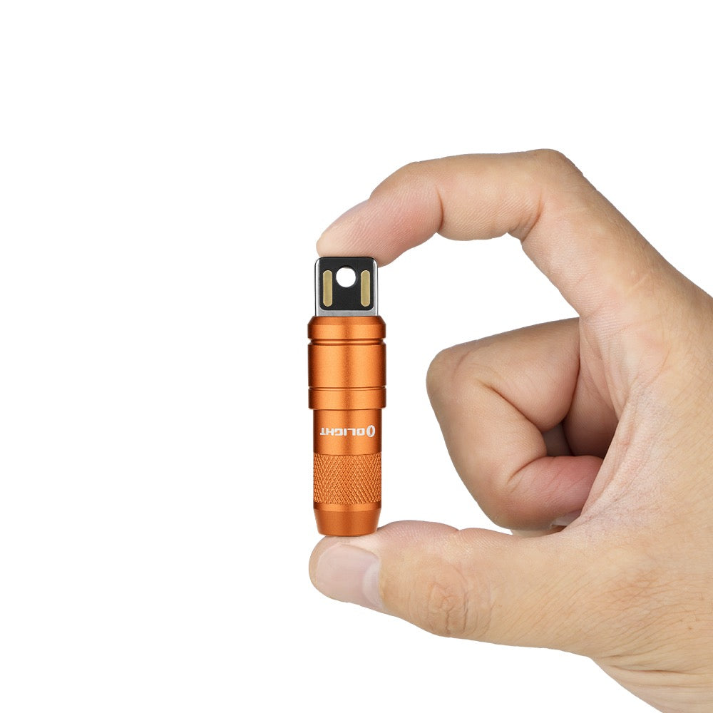 Olight imini 2 Orange held between fingers showing its keychain size