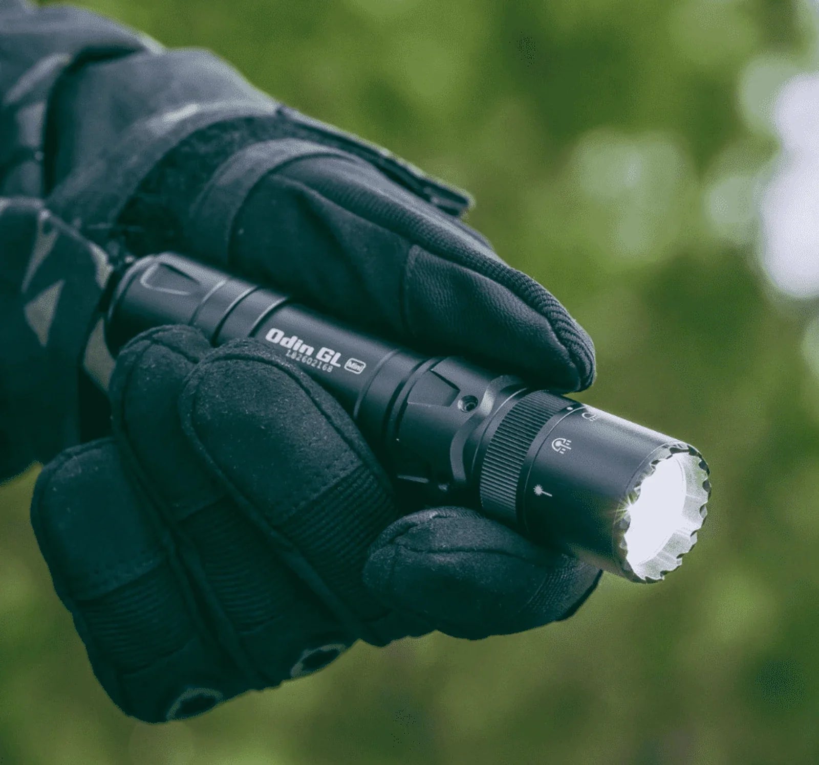Olight Odin GL Mini held in a gloved hand showing its compact size