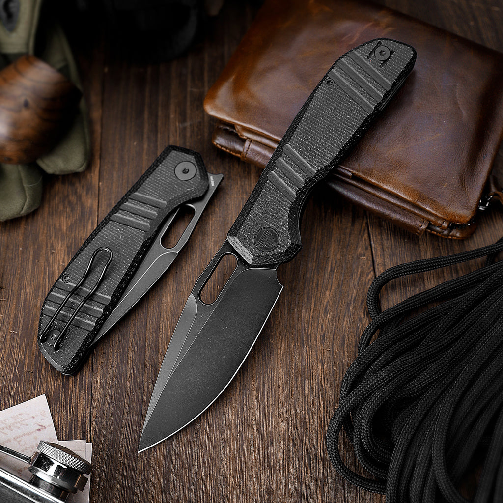 Black tactical folding knife with textured handle and pocket clip