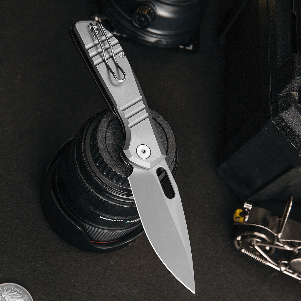 TRIVISA Gecko-S JM04-S-M 3.4" M390 drop point liner lock knife on camera lens
