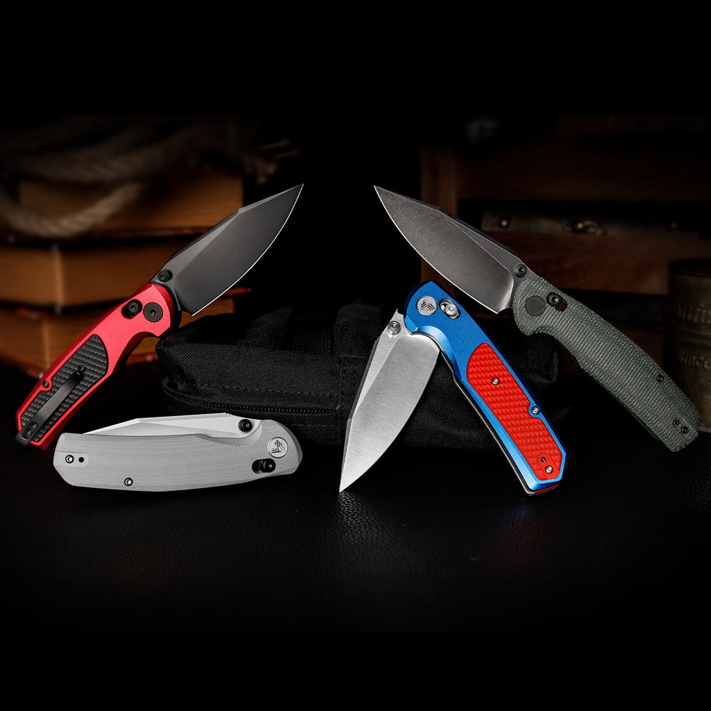 Collection of folding knives with colorful handles and drop point blades, including TRIVISA Hornet-04G
