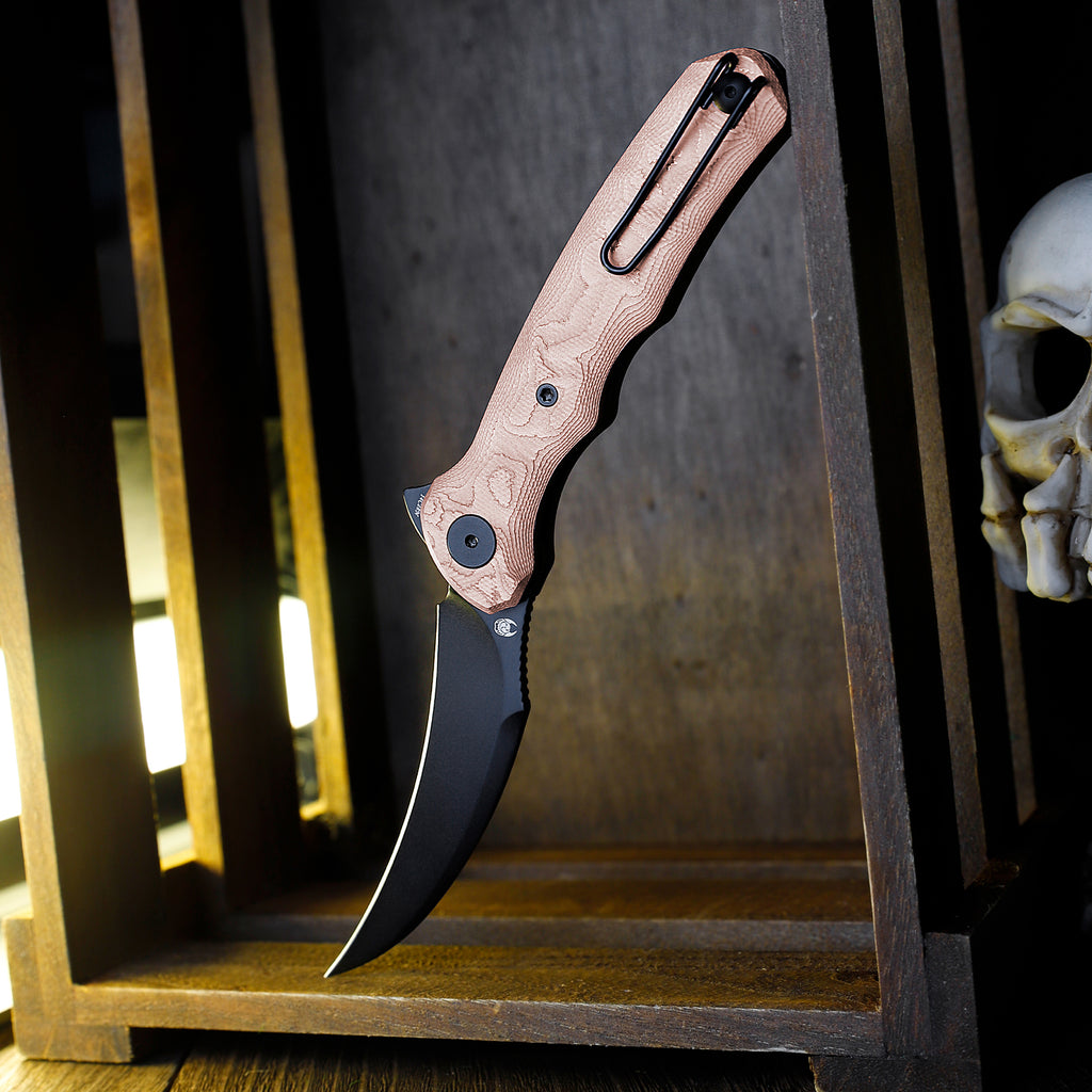 TRIVISA Lacerta-CU TY19-CU-14 3.34 inch black pointed liner lock knife with copper foil handle displayed on wooden shelf