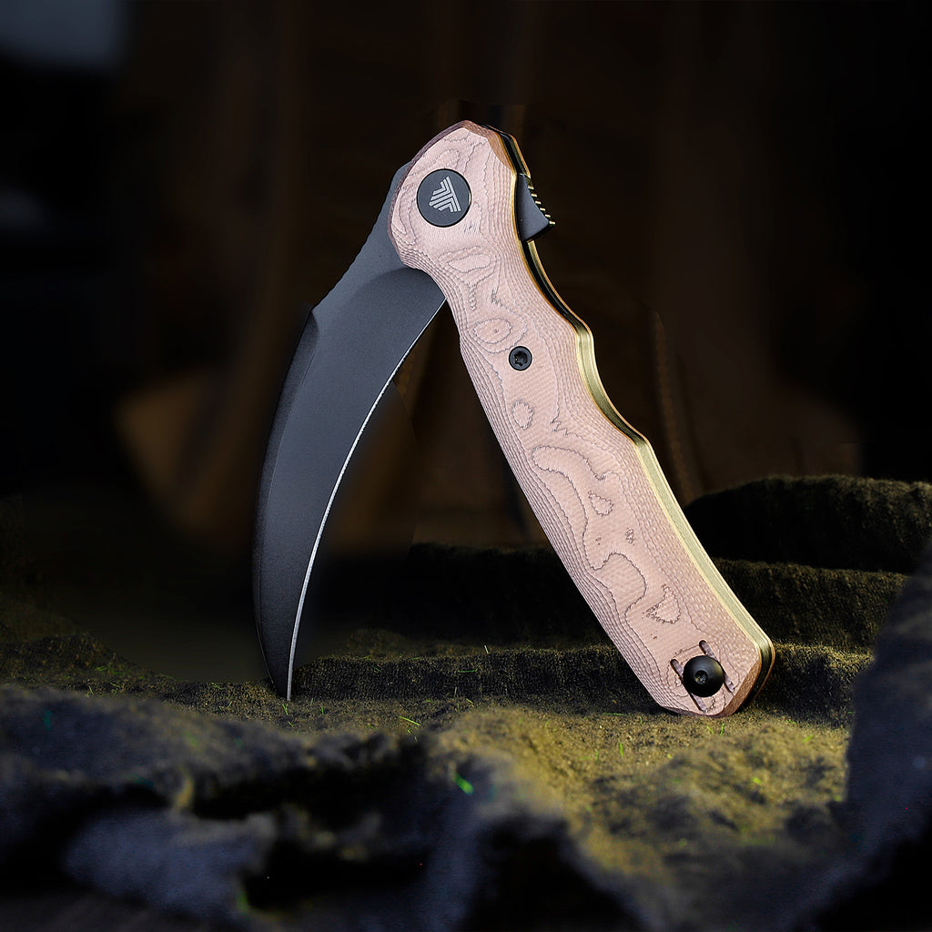 Close-up of TRIVISA Lacerta-CU TY19-CU-14 folding knife with copper handle and black blade on dark background