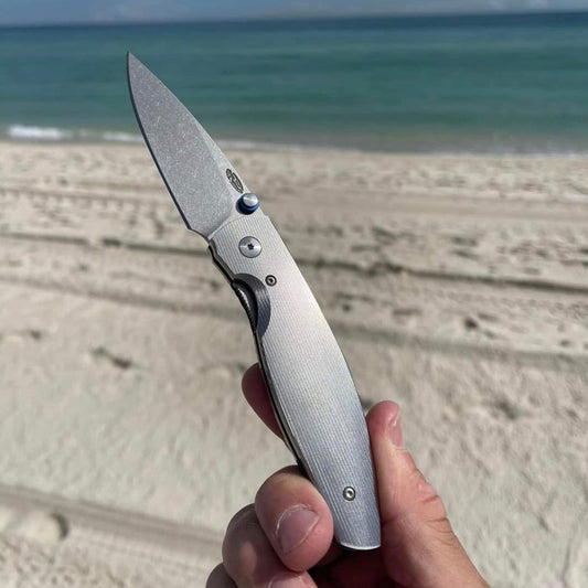 TRM held in hand with beach and ocean in the background
